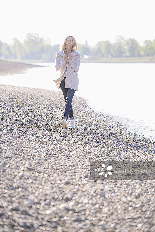 快乐成熟的女人走在河边图片素材