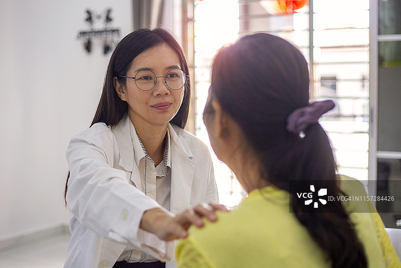 亚洲女医生在家安抚女病人图片素材