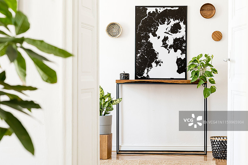 时尚舒适的斯堪的纳维亚室内客厅与木制控制台，墙上的环，立方体，植物和优雅的个人配件。黑色模拟海报地图。家居装饰设计。模板。图片素材