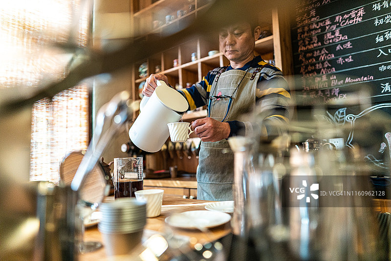 亚洲咖啡店老板正在准备新鲜咖啡图片素材