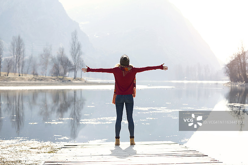 一个年轻的金发女人在冬天的湖边图片素材