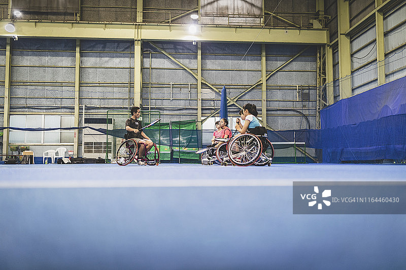 残疾人女运动员在教练的指导下进行轮椅网球训练图片素材