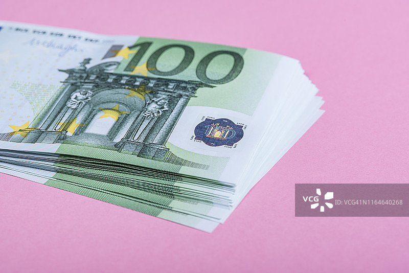 以淡紫色、紫色和粉色为背景的欧元现金。欧元纸币。欧元的钱。欧元的法案。文本。图片素材