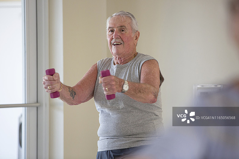 快乐的老人在健身房锻炼图片素材