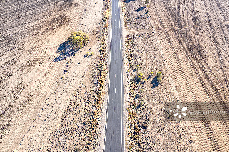 鸟瞰图的一个漫长的道路通过干旱条件下干燥的土壤农地图片素材