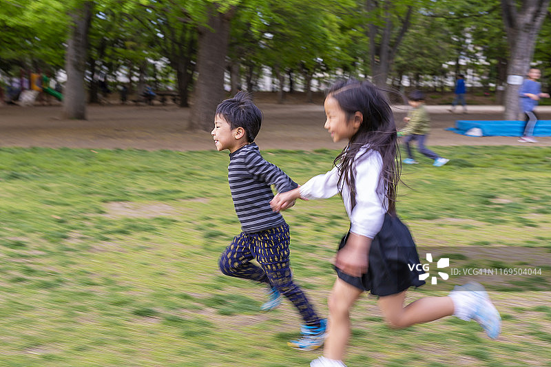 弟弟和妹妹在公园里一起跑步图片素材