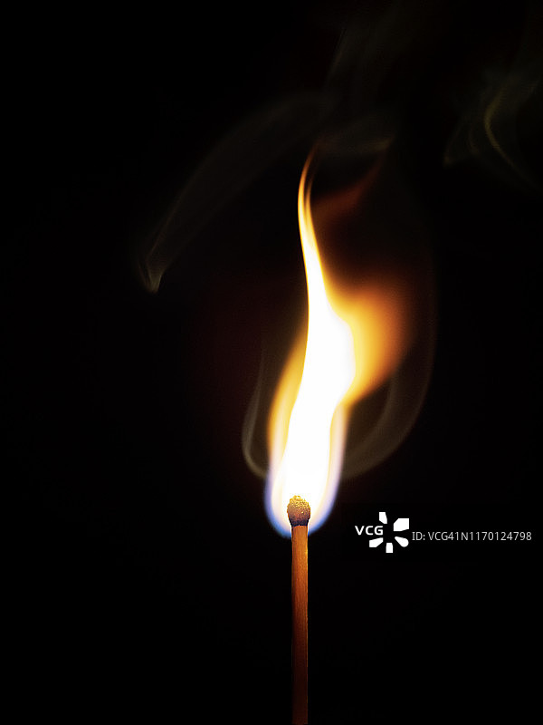 火焰和烟的火柴在黑色的背景。图片素材