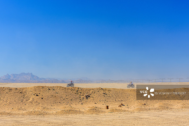 在埃及赫尔加达市附近的阿拉伯沙漠中，人们开着四轮摩托车进行狩猎旅行图片素材
