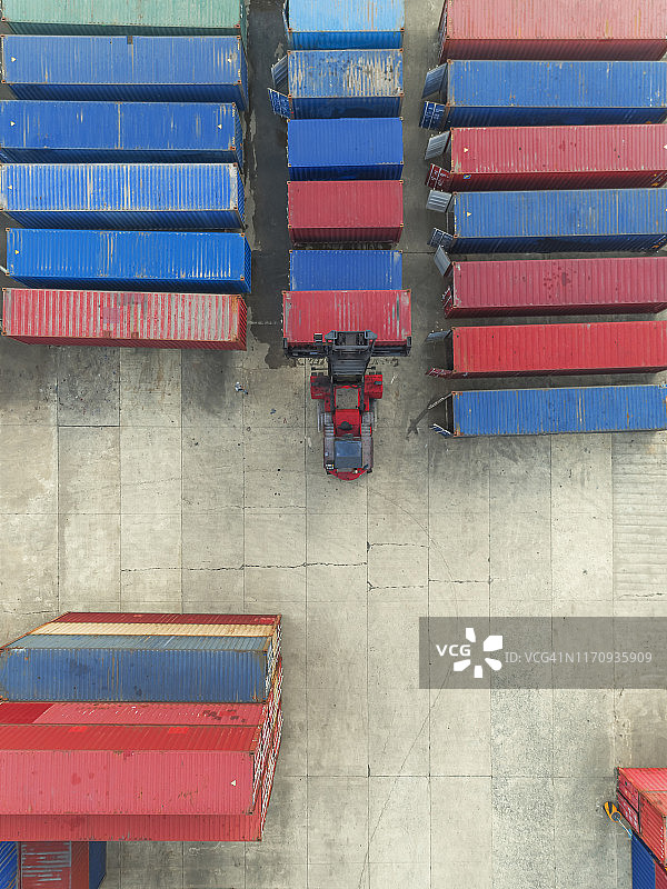 高空俯视图起重机在仓库中吊装集装箱。图片素材