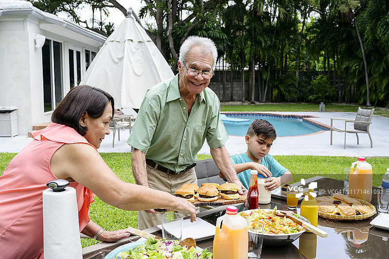 西班牙老夫妇和孙子享受户外午餐图片素材