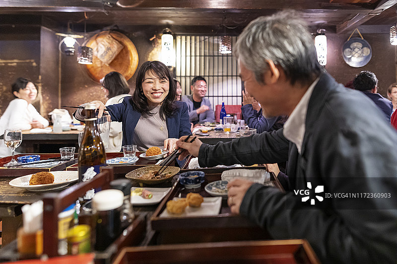 人们在东京的一家餐厅享用晚餐和饮料图片素材