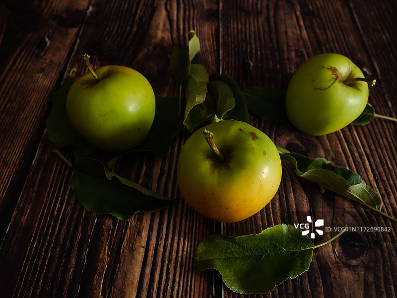秋天的水果和有机食品:三组新鲜的有机苹果从有机苹果树和切好的叶子图片素材