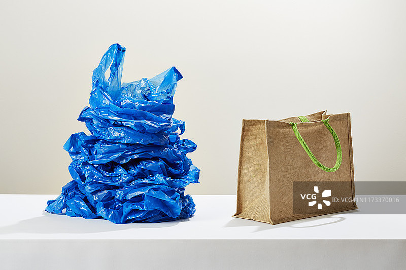 在可重复使用购物袋旁边的一堆塑料购物袋图片素材
