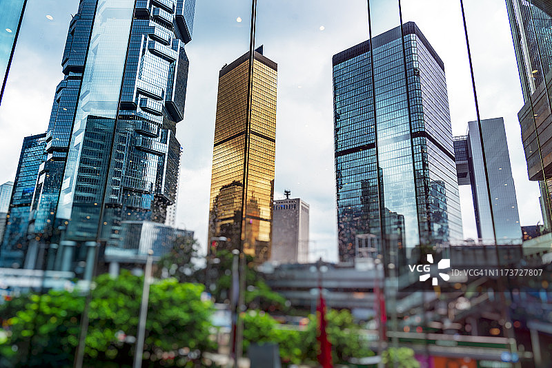现代摩天大楼映照在潮湿的玻璃窗上图片素材