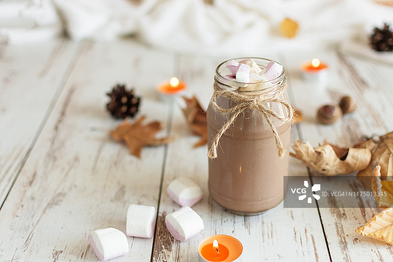 热巧克力可可饮料与棉花糖和肉桂在木制背景。图片素材