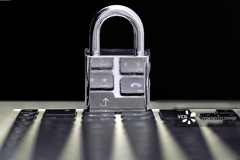 电脑安全概念与一个封闭的挂锁键盘上的黑色背景图片素材