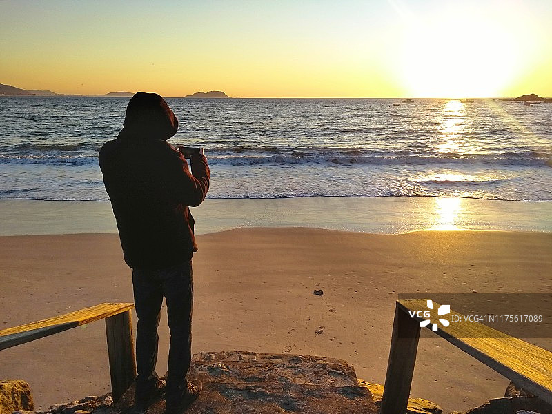 男子拍摄日出- Florianópolis，圣卡塔琳娜-巴西图片素材