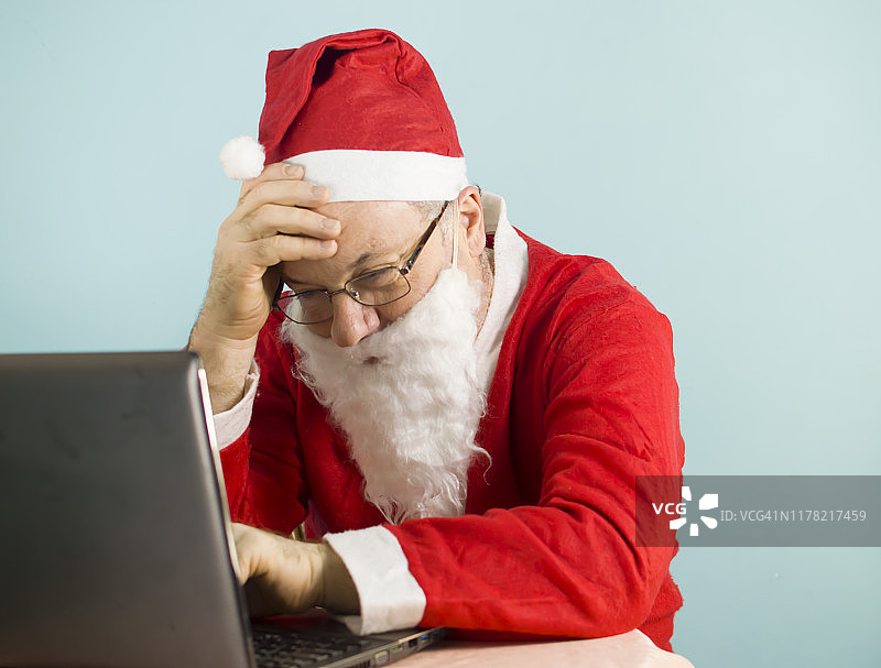 打扮成圣诞老人的商人在用电脑工作图片素材