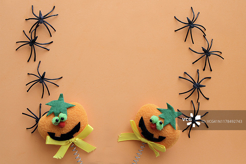 橙色背景下的黑色蜘蛛和南瓜图片素材