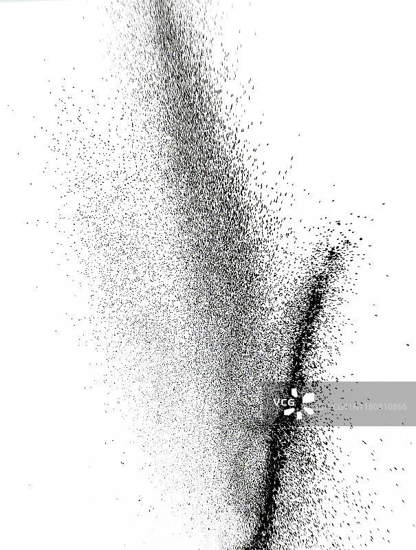 一团黑色的粉末颗粒在白色的背景上碰撞而产生的爆炸。图片素材