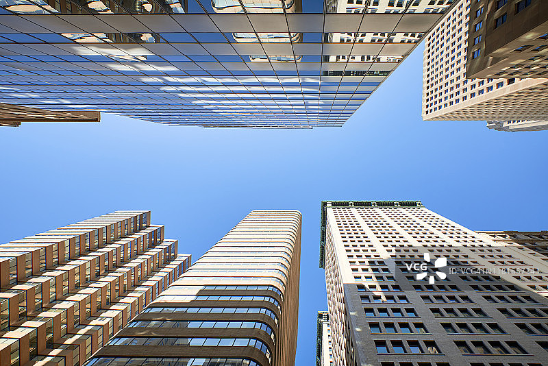 当代玻璃摩天大楼反映了蓝色的天空图片素材