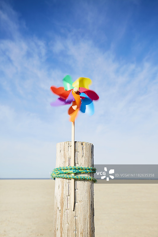 沙滩上五颜六色的风车映衬着夏天的天空图片素材