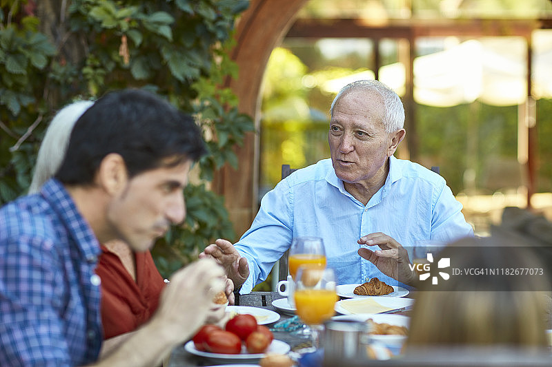 一对西班牙老夫妇在家庭早餐桌上聊天图片素材