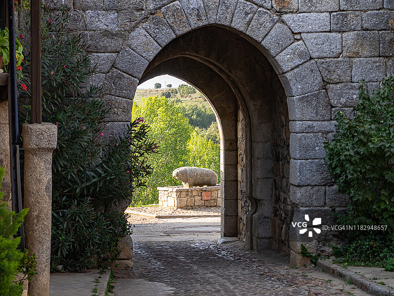 通往城市的大门。风景优美的秋天穿过一个拱形的中世纪村庄的围墙图片素材
