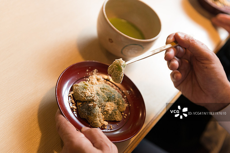 在京都一家餐厅里，日本资深男子正在吃Warabimochi甜点图片素材