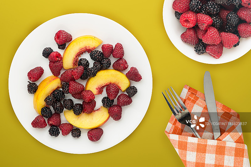 饮食,健康食品。黑莓、覆盆子、油桃放在盘子里的白色盘子里。素食食物的背景俯视图。图片素材