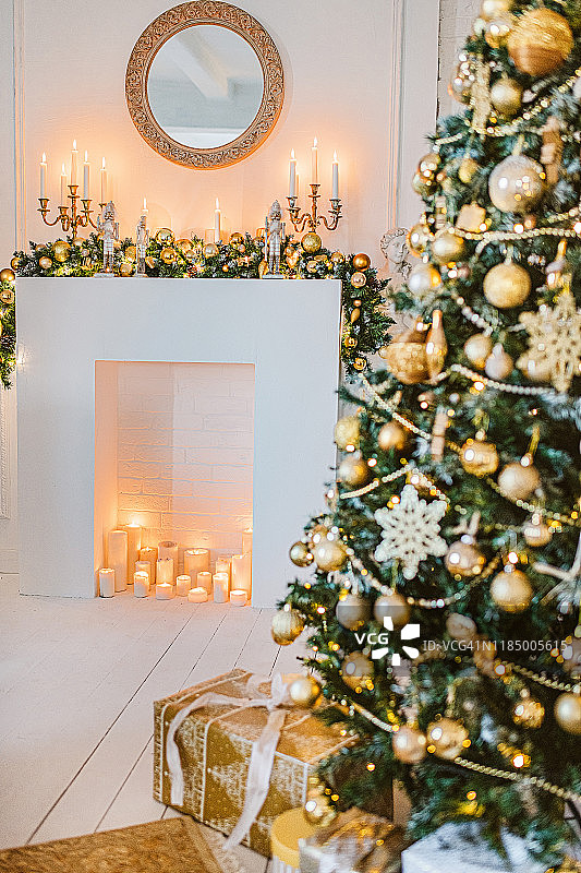 圣诞客厅装饰，白色和金色的颜色室内装饰背景，圣诞家庭装饰用礼物，圣诞灯和圣诞树室内图片素材