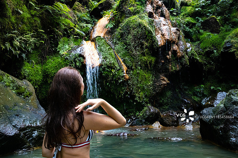 女子在亚速尔群岛享受天然温泉和瀑布。图片素材