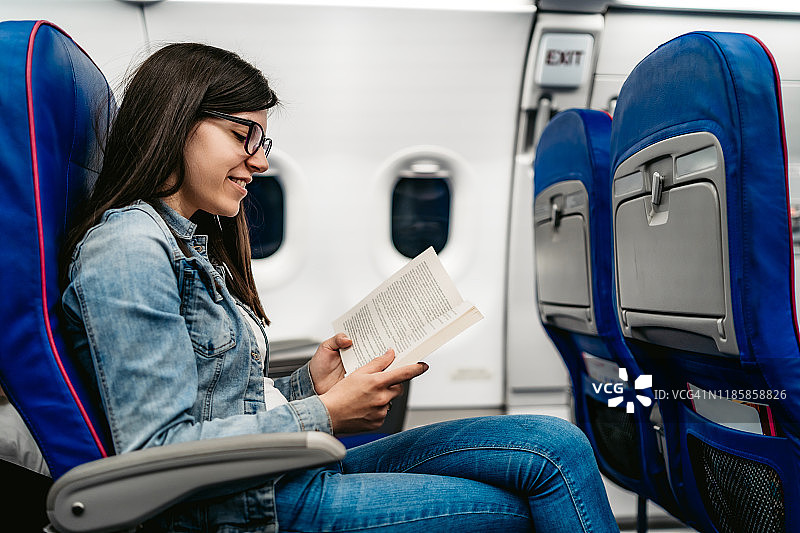 在飞机上看书的女人图片素材