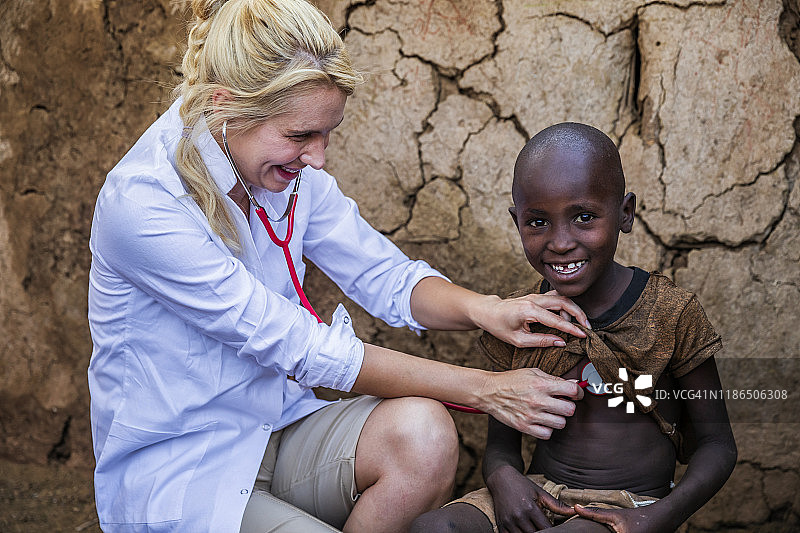 在肯尼亚的一个小村庄，医生正在检查一个年轻的非洲男孩图片素材