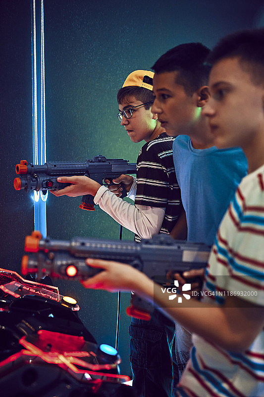 青少年朋友在游乐场用枪射击图片素材
