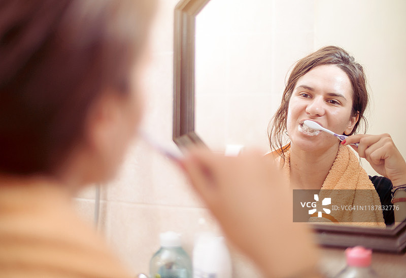 在浴室镜子前护理牙齿图片素材