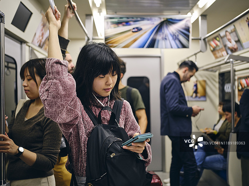 拥挤的日本地铁上的年轻女子图片素材