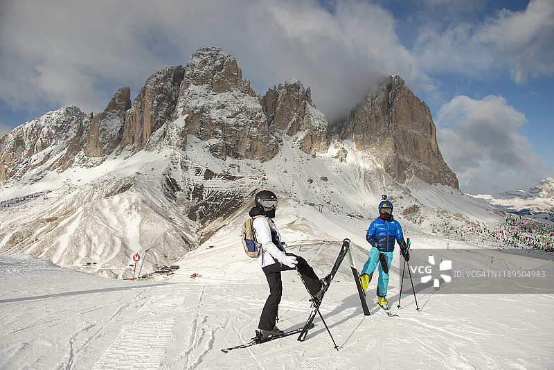 母亲和儿子滑雪在Val Gardena，塞拉隆达赛道，意大利Dolomites阳光明媚的滑雪胜地图片素材