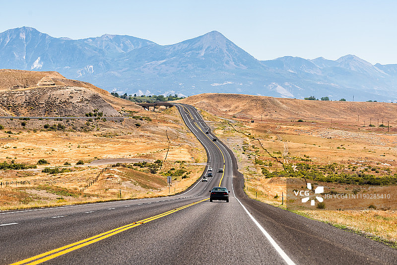 位于科罗拉多州蒙特罗斯附近的92号公路通往宝尼亚，沿途有干燥的沙漠景观和岩石山脉，街道上有汽车行驶图片素材