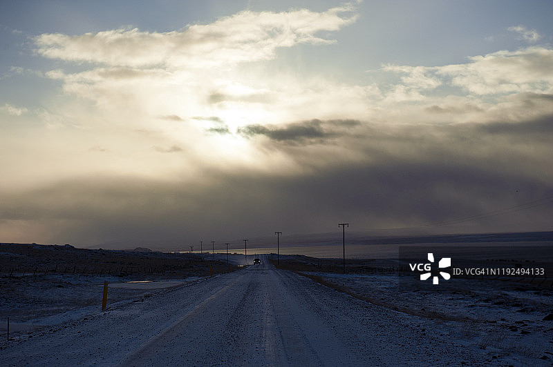 冰岛西北部Hvammstangi附近蜿蜒的道路和戏剧性的暴风雨天空图片素材