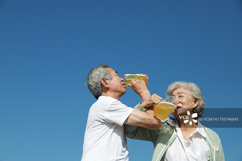 老夫妇一起在户外喝啤酒图片素材