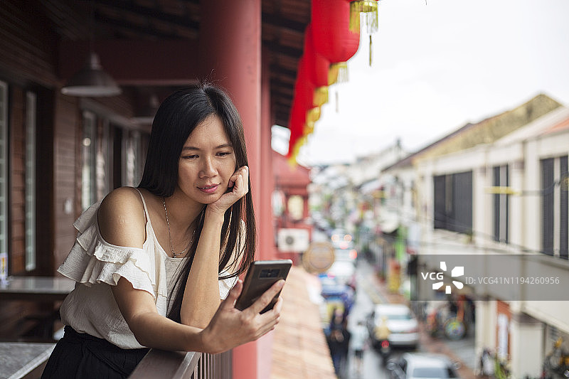 亚洲女游客正在发短信在中国城的市场图片素材