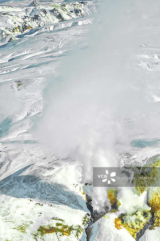 冰岛雪山顶上的间歇泉喷出的蒸汽图片素材
