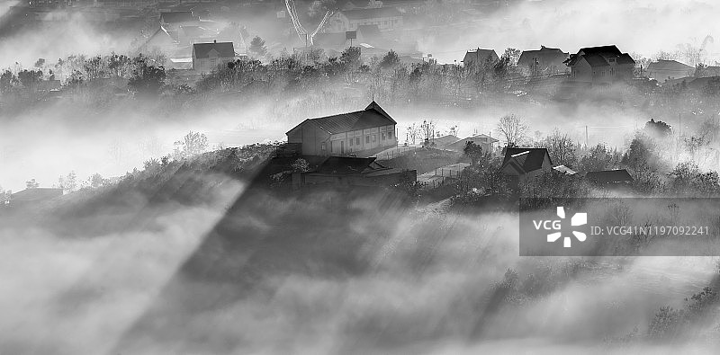 美丽的新教教堂在雾与神奇的光和梦的风景在日出，照片由黑白版本图片素材