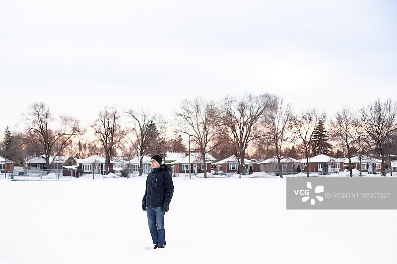 一个人在白雪覆盖的公园里散步图片素材