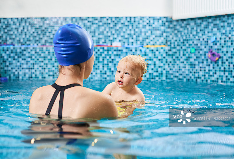 母亲和婴儿在游泳池训练图片素材