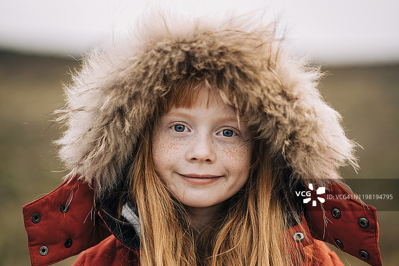 可爱的微笑女孩与雀斑在毛皮头巾图片素材