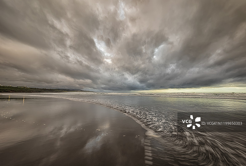 新西兰，汤加普鲁图，黄昏时沙滩上的灰色云层图片素材