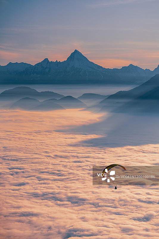一个滑翔伞的剪影飞行在云地毯在日落，Gaisberg，萨尔茨堡，奥地利图片素材