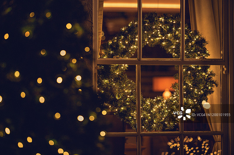 透过客厅里圣诞花环的窗户看到的景色图片素材